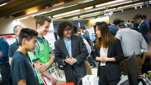 One male and one female student presenting their project to two fellow male students.