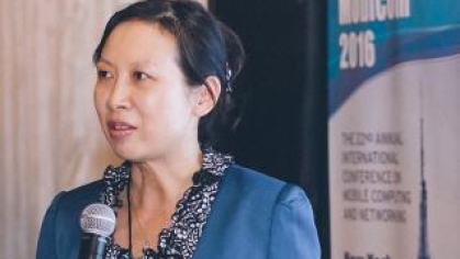 Yingying Chen speaking while holding a microphone during a presentation