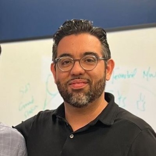 Head shot of male with short black hair, a beard and a moustache wearing eyeglasses.