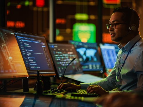 IT Developer Working on Computer in Monitoring Control Room. 