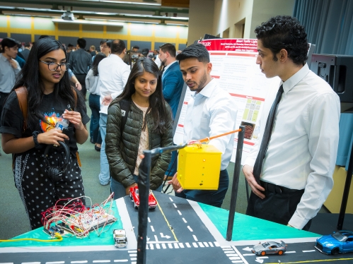 Two male students present their project to two female students.