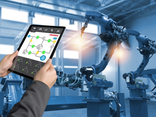 Engineer hand using tablet, heavy automation robot arm machine